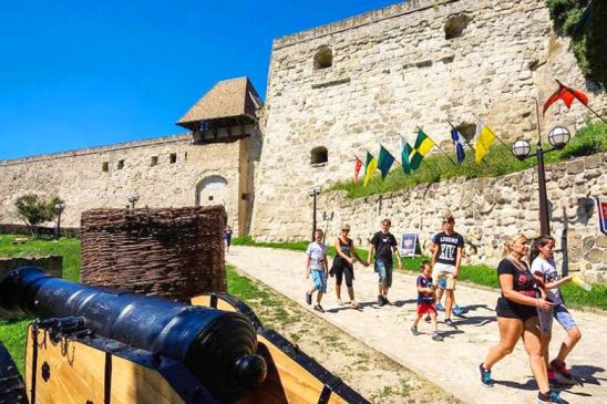 Látogatók az egri vár falai előtt sétálnak