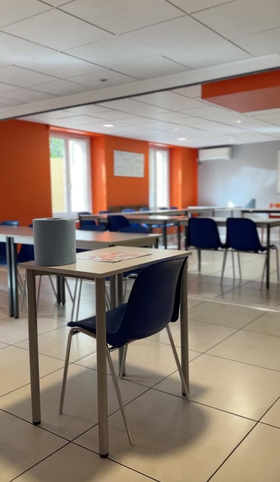 Moderner Klassenraum mit blauen Stühlen und hellen Wänden in einer Sprachschule.