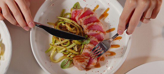 A delicious dish of sliced tuna and zoodles artfully plated, ready to be enjoyed.