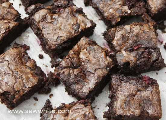 Close up of black forest brownies. Crispy brownies with lovely top and squidgy centre topped with cherries, raspberries and blackberries. 