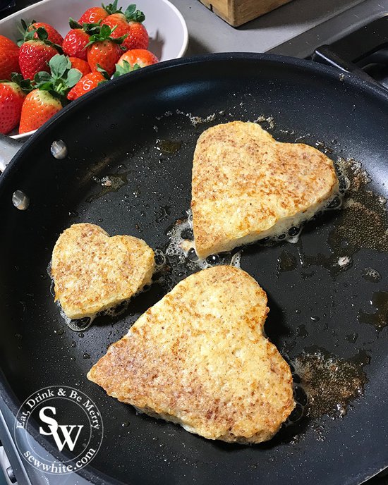 Heart shaped Valentine's French Toast cooking in the pan