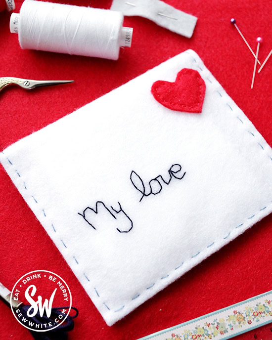 felt envelope with embroidered name on and red heart for a stamp.