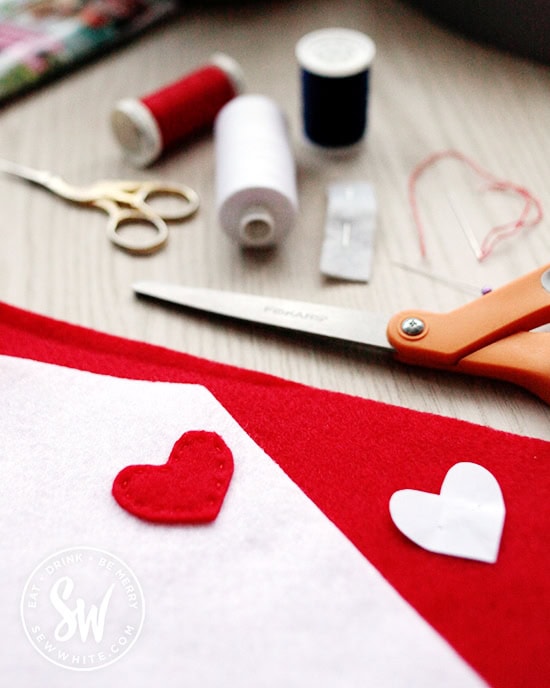 Cutting out a red heart out of felt for the stamp on the felt envelope.