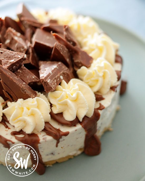 Toblerone Cheesecake with drizzled chocolate, cream swirls and Toblerone pieces on top