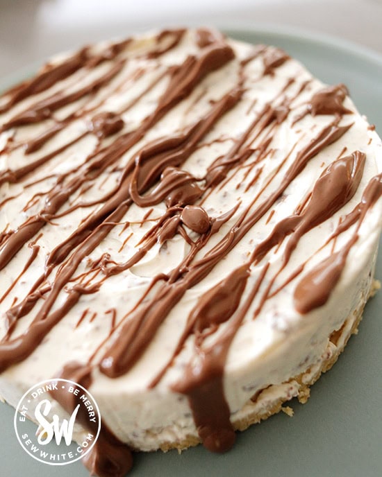 Drizzling molten chocolate over the toblerone cream base of the cheesecake.