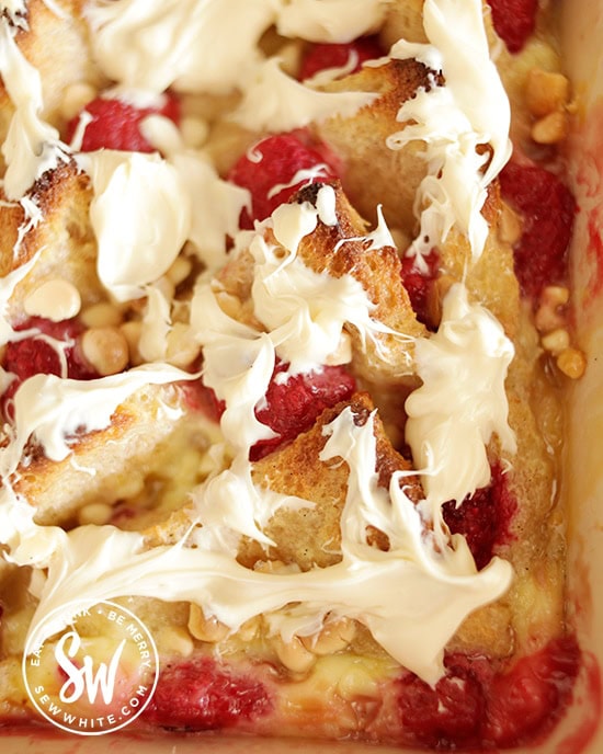 white chocolate drizzled over the golden baked Raspberry Bread and Butter Pudding