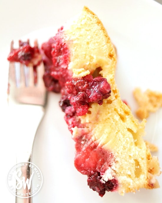 A beautiful slice of summer fruit sponge pudding with a layer of yellow sponge and chunky berries.