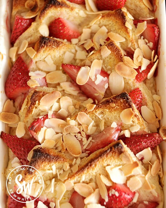 Golden brown toast almonds on a strawberry bread and butter pudding fresh from the oven