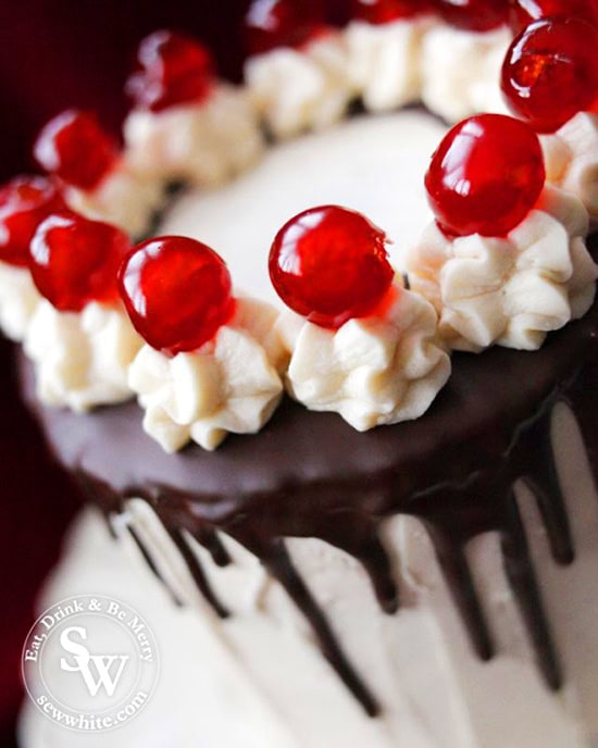 easy black forest layer cake with chocolate drip and glace cherries as decoration