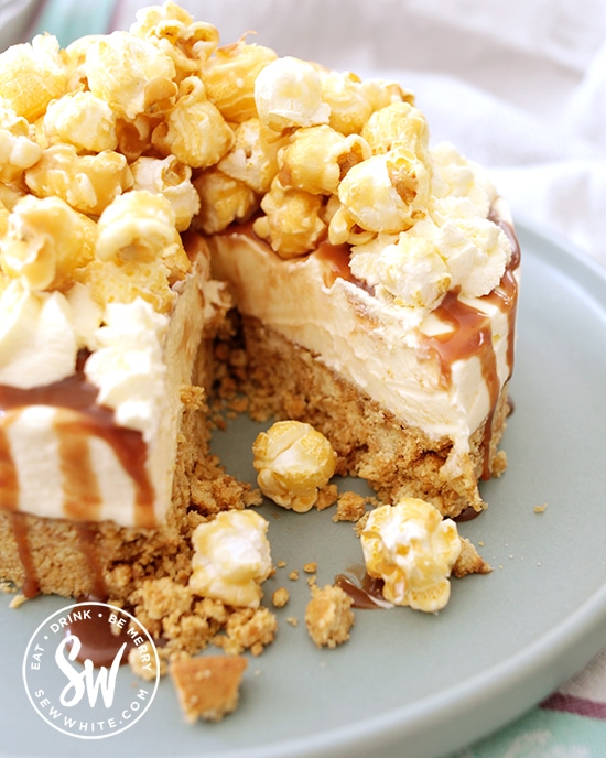 toffee popcorn no bake cheesecake drizzled with toffee sauce and covered with popcorn.