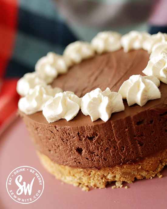 Guinness chocolate cheesecake decorated with white cream pipped on top to look like a pint of Guinness.