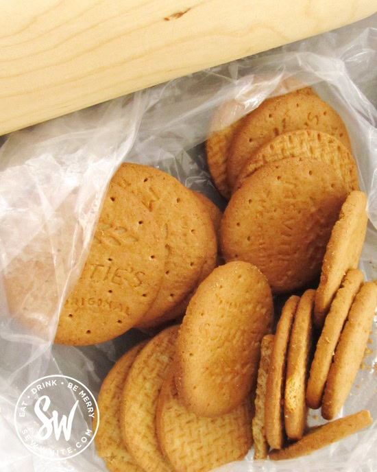 digestives biscuits in a bag with a rolling pin to be turned into a crumb