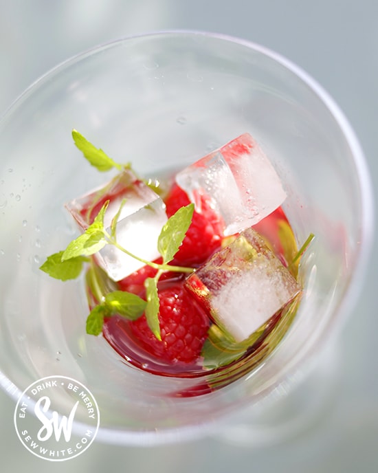 fresh raspberries and mint in a cocktail glass