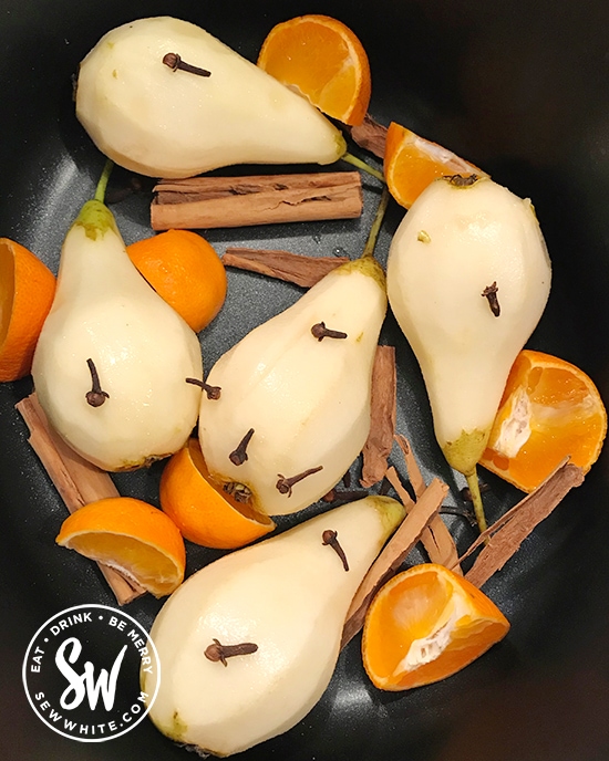 orange segments, cinnamon and cloves in a slow cooker with pears