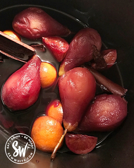 mulled wine pears in a slow cooker dyed red from the wine