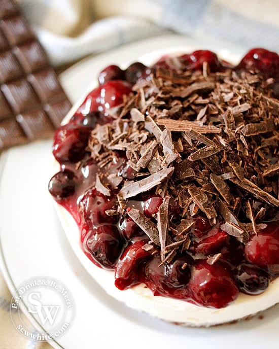 black forest cheesecake close up of the shards of chocolate and cherry compote on the creamy cream cheese base