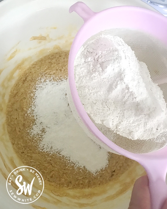 flour being sieved in to the cake mix