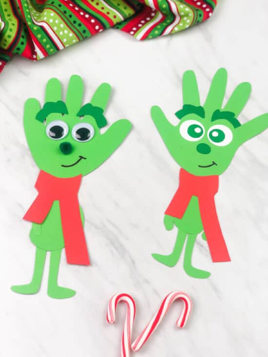 nopin="nopin" Grinch craft for kids featuring a green handprint