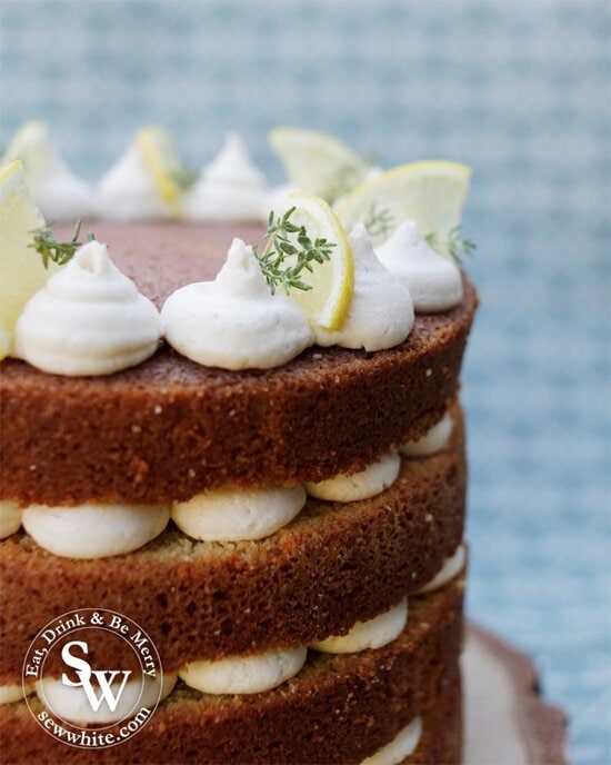 Close up view of the gin cocktail cake layers. Golden brown cake with white buttercream swirls.