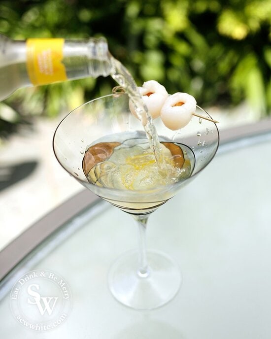 Lemon Lychee Martini being made. Double lemon mixer being poured over the top into the glass. 