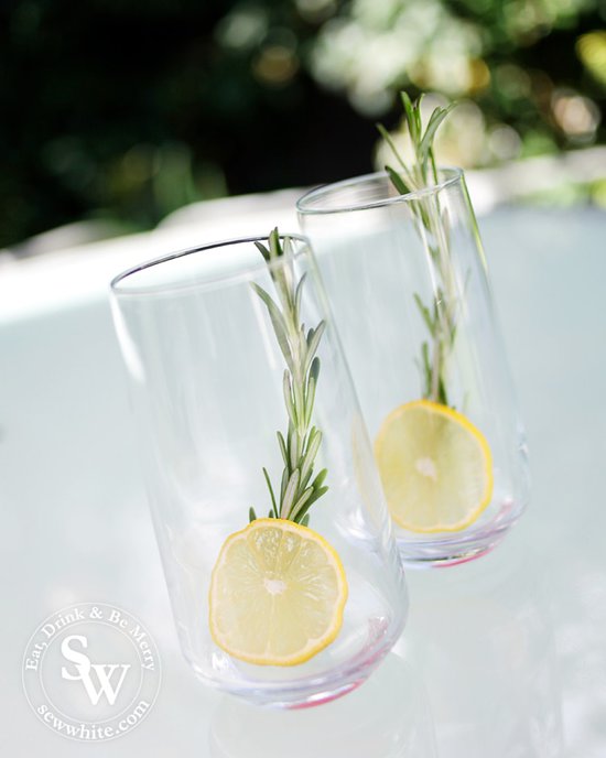 A slice of bright yellow lemon and large green sprig of rosemary.