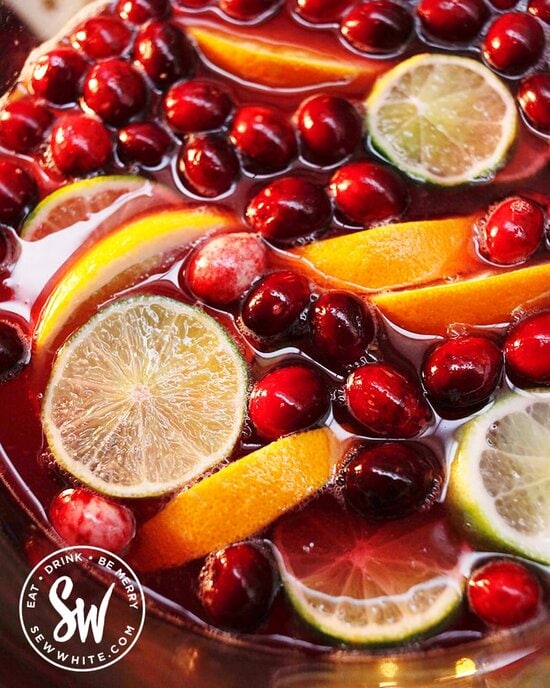 Close up of the fresh cranberries, lime slices and orange slices in the Christmas punch.