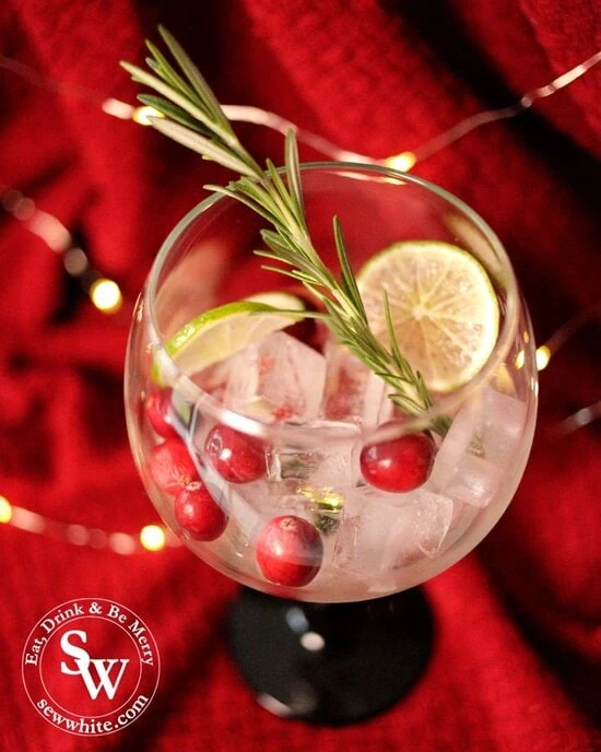 Making up a beautiful Christmas gin cocktail with fresh cranberries, rosemary and lime for the Christmas Cranberry Gin Cocktail