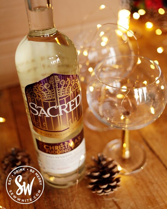 Scared Christmas pudding gin in time for Christmas made with whole Christmas puddings next to golden gin and tonic bowl glasses with fairy lights in the drink gift guide