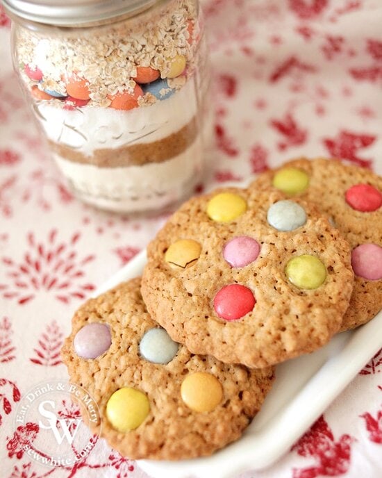 Cookie jar next to 3 finished cookies on a white plate