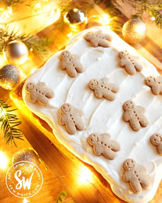 easy gingerbread traybake topped with cream cheese frosting and gingerbread men. 