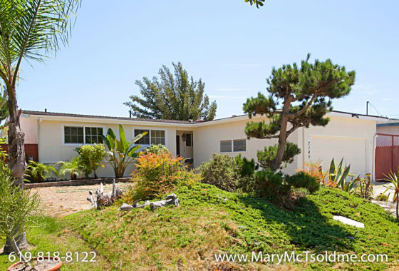 Mid-century ranch style home at 7145 Belden Street in Linda Vista featuring a cream exterior, low-maintenance drought-tolerant landscaping, and a sculptural pine tree in the front yard.