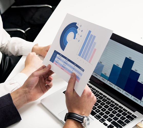 Business professionals discussing data charts and graphs in a modern office setting.