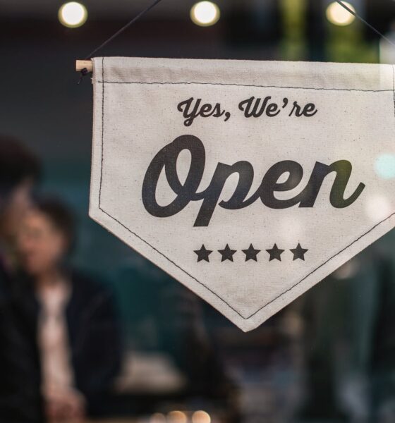 shallow focus photo of white open sigange. Small Business Saturday