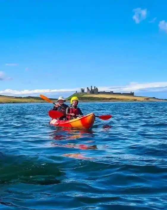 Kayakers on calm blue waters.