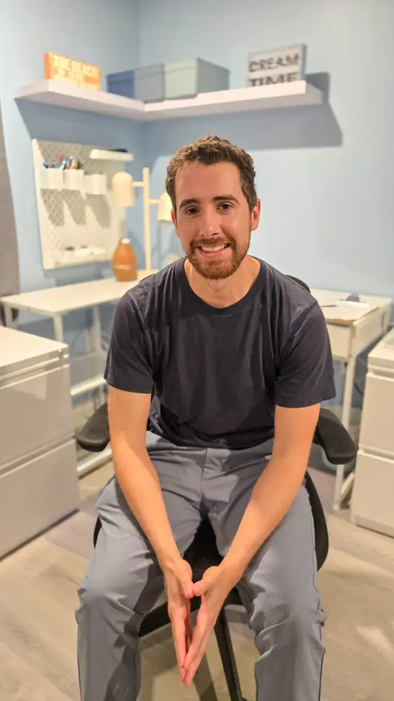 male therapist sitting in chair leaning forward