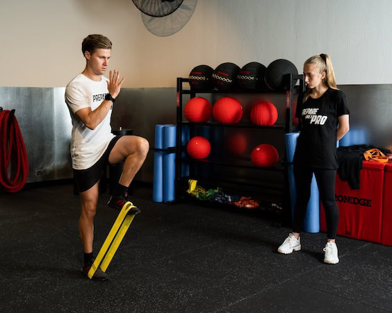 Coach assessing an athlete's sprint technique and running mechanics