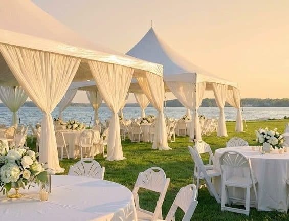 Elegant high-peak event tent setup with tables and chairs for an outdoor party rental in Murrells Inlet SC.