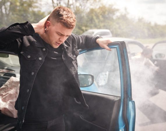 Injured driver making a phone call after a car accident