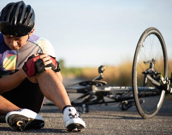 Man injured after falling off bicycle on the side of a Texas road, symbolizing the dangers of bike accidents.