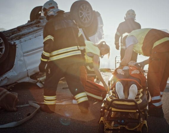 Firefighters and paramedics assisting crash victim after rollover accident on I-45 in Houston