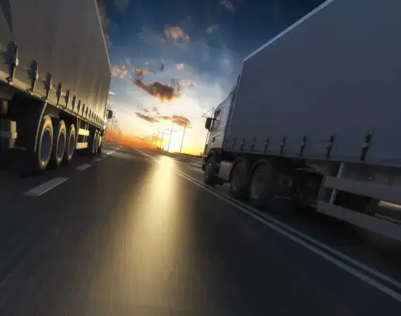 Two 18-wheelers driving down a Houston highway, representing commercial truck traffic involved in serious 18-wheeler accidents in Texas.