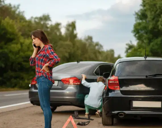 Woman calling for help after a car crash on a Houston road, ideal example for a Houston car wreck attorney case
