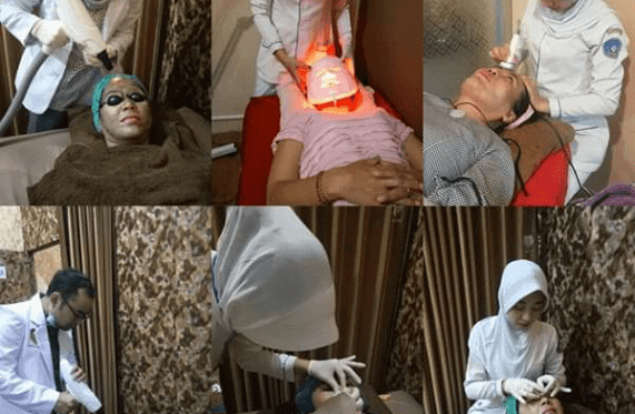 Klinik kecantikan — teknisi memakai jas laboratorium sedang melakukan perawatan wajah pada klien di ruang perawatan