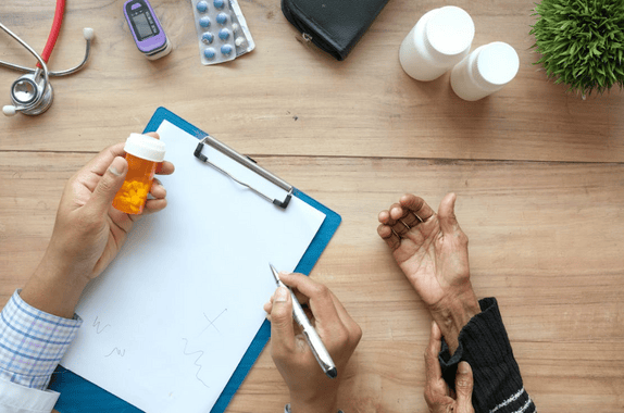 Doctor consulting a patient and prescribing medication on a clipboard