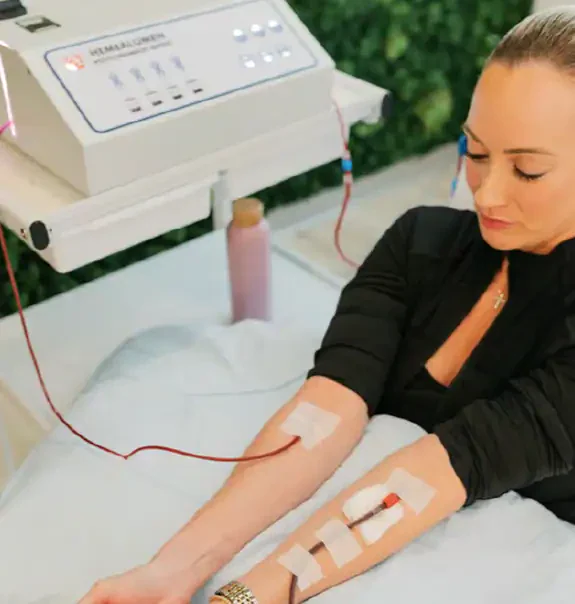 Young woman comfortably receiving EBO2 Ozone Therapy through dual IV lines 