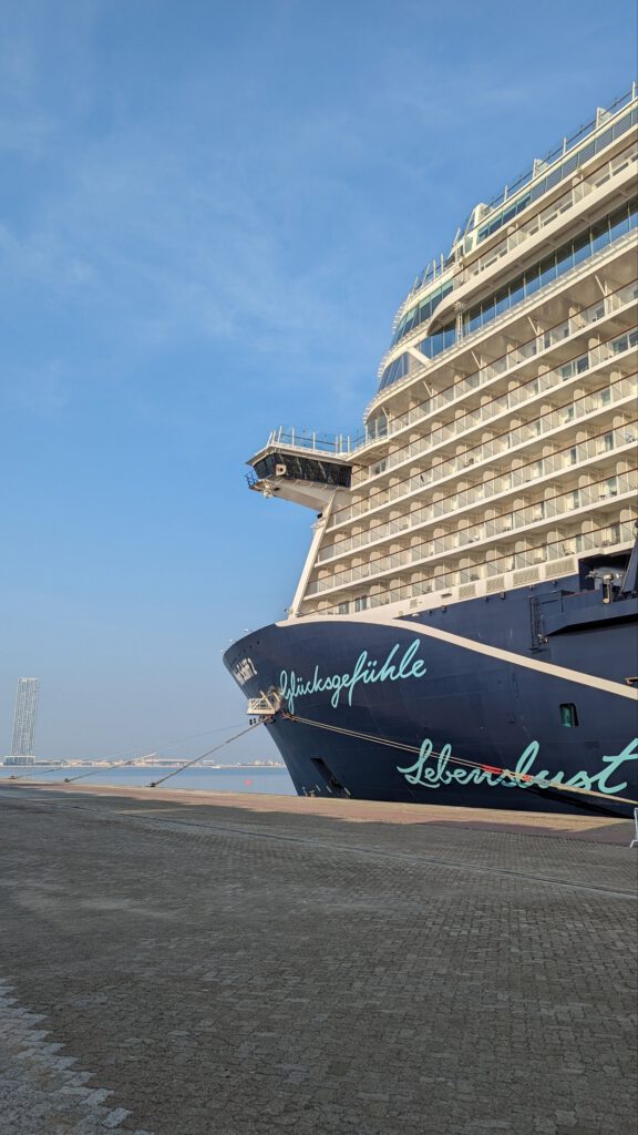 die mein schiff 2 in einem hafen, mit blick auf den bug des schiffes, auf dem die worte "glücksgefühle" und "lebenslust" geschrieben stehen.