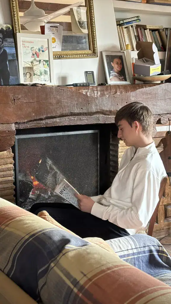 daniel sentado leyendo junto a. la chimenea caballero