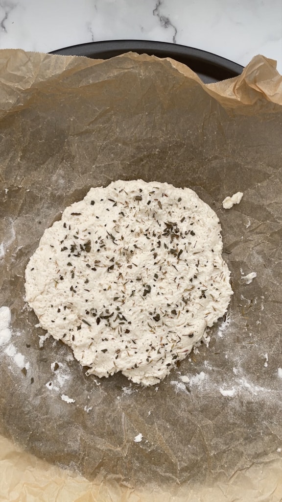 Seasoned high protein pizza dough on parchment paper. 