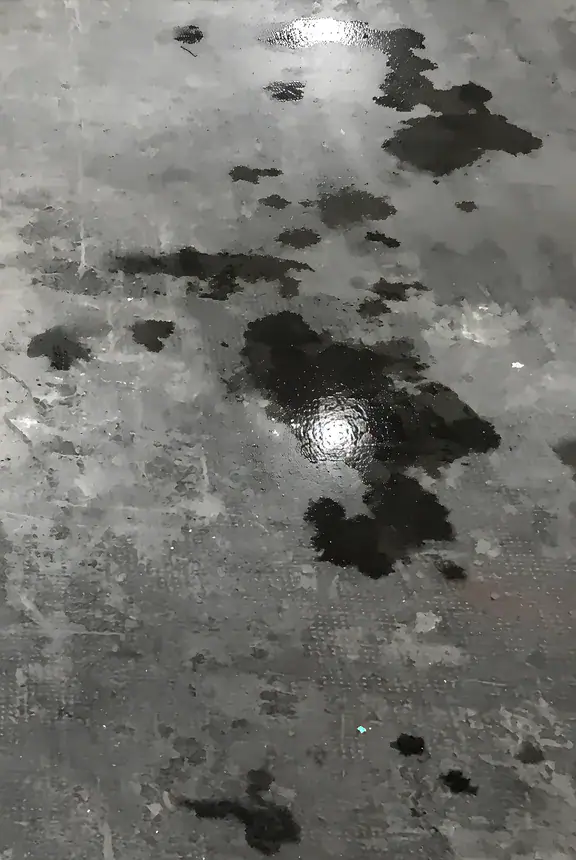 Pavimento industriale in calcestruzzo contaminato da macchie di olio prima dell'intervento di ripristino
