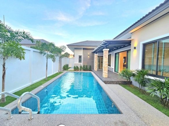 Modern luxury home with rectangular swimming pool and tropical landscaping